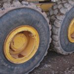 close up shot of a heavy trucks tires. Two tires are shown on a dirt road