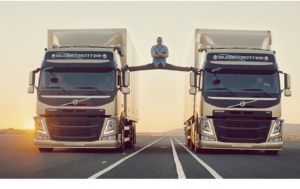 A picture of actor Jean Claude VanDamme doing the splits between 2 Volvo Rigs driving down a road